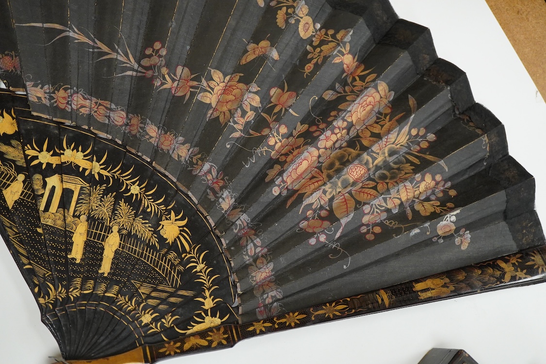 Four 19th century Chinese gilt-decorated black lacquer fans with figure painted leaves, two cased, largest 41cm